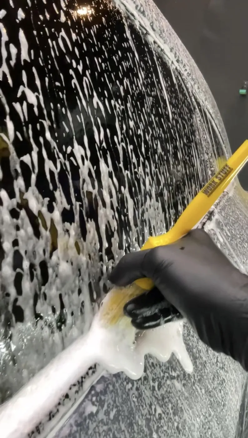 泡を乗せたガラス面をスキージーで水切りする様子
